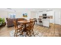 Inviting open concept kitchen/dining area with white cabinets, stainless steel appliances and hardwood flooring throughout at 120 Gray Hawk Dr, Rockwell, NC 28138