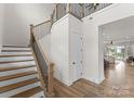 Bright foyer featuring hardwood floors, a staircase with iron railings, and a welcoming atmosphere at 12202 Anne Blount Aly, Davidson, NC 28036