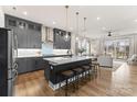 Open-concept kitchen with modern gray cabinets, a large island with seating, and stainless steel appliances at 12202 Anne Blount Aly, Davidson, NC 28036