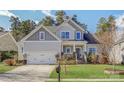 Charming two-story home with a well-maintained lawn, a two-car garage, and a welcoming front porch at 17609 Caddy Ct, Charlotte, NC 28278