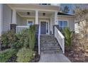 Inviting front porch with stone steps, white railings, and a stylish front door with decorative wreath at 17609 Caddy Ct, Charlotte, NC 28278