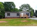 Charming single-story home with gray siding and a wooden front porch in a landscaped yard at 2013 Vick Wilson Rd, Shelby, NC 28152