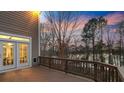 Spacious wood deck with railing and lake view through mature trees at 208 Woodwinds Dr, Mount Holly, NC 28120