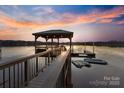 Picturesque dock with covered seating area extending into calm water at 208 Woodwinds Dr, Mount Holly, NC 28120
