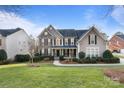 Beautiful two-story home with manicured lawn and lush landscaping at 208 Woodwinds Dr, Mount Holly, NC 28120