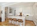 Open-concept kitchen features an expansive island with bar stool seating, white cabinets, and modern lighting at 2509 Montrose Ct, Charlotte, NC 28207