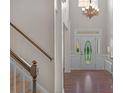 Bright, welcoming foyer with a glass-paneled door, staircase, and elegant chandelier at 2711 Liberty Hall Ct, Waxhaw, NC 28173