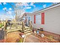 Home exterior with brick foundation, wooden deck, and well-maintained landscaping at 334 Hillcrest Dr, Mooresville, NC 28115