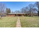Charming brick ranch home with a walkway leading to the front porch and a well-maintained lawn at 624 Patricia Ave, Harrisburg, NC 28075