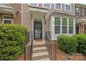 Inviting front entrance with a black screen door, concrete steps and black metal railings at 6846 Colonial Garden Dr, Huntersville, NC 28078