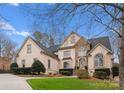 Stately residence with a stone-accented entrance, lush lawn, mature trees and concrete circular driveway at 1025 Seminole Dr, Waxhaw, NC 28173