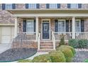 Inviting front entrance with covered porch, decorative columns and manicured shrubbery at 1005 Forbishire Dr, Matthews, NC 28104