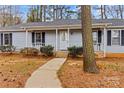 Welcoming home featuring a cozy porch with white railing, mature landscaping, and a winding sidewalk leading to the entrance at 101 Fairfax Dr, Salisbury, NC 28146