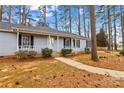 Quaint home with light blue siding, black shutters, and covered front porch surrounded by mature trees and natural landscaping at 101 Fairfax Dr, Salisbury, NC 28146