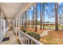 View from the covered front porch overlooking mature trees and the front yard showcasing the property's curb appeal at 101 Fairfax Dr, Salisbury, NC 28146