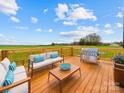 A large wooden deck featuring a grill and outdoor seating with a scenic view of the surrounding field at 1300 Austin Chaney Rd, Wingate, NC 28174