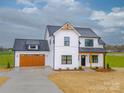 Charming two-story modern farmhouse with a brown garage door and beautifully landscaped yard at 1300 Austin Chaney Rd, Wingate, NC 28174