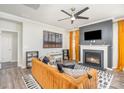 Inviting living room with a fireplace, stylish furniture, a modern ceiling fan, and hardwood-style floors at 19113 Hawk Haven Ln, Charlotte, NC 28278