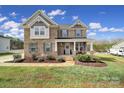 Charming two-story brick home featuring a welcoming front porch, landscaped yard, and beautiful architectural details at 2167 Whispering Winds Dr, Rock Hill, SC 29732