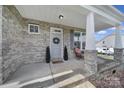 Inviting front porch featuring brick columns, a cozy sitting area, and a decorative wreath on the front door at 2167 Whispering Winds Dr, Rock Hill, SC 29732