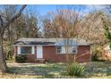 Classic single-story brick home with a traditional design, framed by mature trees, offering charm and curb appeal at 3030 Crawford Ave, Gastonia, NC 28052