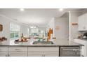 Open kitchen featuring granite countertops, a stainless steel sink, and a view into the dining and living areas at 3878 Fairlady Ln, Fort Mill, SC 29707