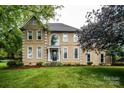 Stately two-story home with tan stucco, manicured lawn, and mature trees at 4825 1St Street Nw Ct, Hickory, NC 28601