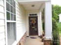Inviting front porch with decorative door and stone accents, enhancing the home's charm and curb appeal at 5963 Pale Moss Ln, Charlotte, NC 28269