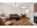 Cozy living room featuring hardwood floors, a ceiling fan, and a fireplace at 811 Gentlewinds Ct, Fort Mill, SC 29708