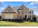 Charming two-story brick home with a lush green lawn and manicured landscaping at 9433 Wallace Pond Dr, Huntersville, NC 28078