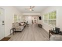 Bright living room featuring laminate flooring, large windows, and inviting seating arrangements at 9937 Harwood Ln, Charlotte, NC 28214