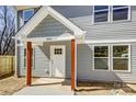 A detailed view of the home's entrance, showcasing a white door and rustic wood posts at 1045 Gaither Nw Pl, Concord, NC 28027