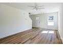 An open-concept living room with hardwood floors, natural light, and a modern ceiling fan at 1045 Gaither Nw Pl, Concord, NC 28027