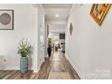 Inviting hallway with hardwood floors and modern decor leading to the living area, offering a seamless transition at 11518 Solstice Way, Huntersville, NC 28078