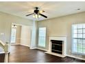 Living room featuring dark wood floors, fireplace, ceiling fan and lots of natural light at 12044 Brownestone View Dr, Charlotte, NC 28269