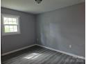 Comfortable bedroom with natural light from the window and modern woodgrain flooring at 126 Lowry St, Chester, SC 29706