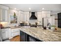 Elegant kitchen with granite countertops, a stylish range hood, and custom white cabinetry at 1263 Crooked Stick Dr, Rock Hill, SC 29730