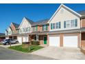 A row of brick townhomes with green shutters, garages, driveways, and green lawns at 2021 Lennox Square Rd, Charlotte, NC 28210