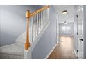 Carpeted staircase with light-colored walls, wooden handrail and landing in a well-lit home at 2021 Lennox Square Rd, Charlotte, NC 28210