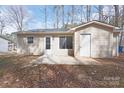 Back of house shows vinyl siding, patio, and access door into additional space at 207 American Dr, Salisbury, NC 28147