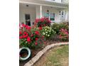 Charming home featuring lush rose bushes in red, pink, and yellow hues, adding vibrant color to the landscape at 2076 Brightflower Ln, York, SC 29745