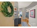 Inviting foyer with hardwood floors, stylish storage, and a decorative wreath on the front door at 210 N Church St # 1413, Charlotte, NC 28202