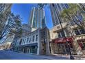 A vibrant city street featuring charming architecture beneath towering skyscrapers and sunny blue skies at 210 N Church St # 1413, Charlotte, NC 28202