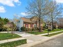 Inviting two-story brick home with a well-maintained lawn, mature trees, and a private driveway at 2907 Blackburn Dr, Waxhaw, NC 28173