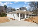 Side angle showing modern new home with ample drive, trimmed front yard, and spacious front porch at 407 S Spargo St, Dallas, NC 28034