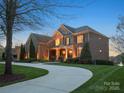Stately brick home with manicured lawn, mature trees, and elegant curb appeal at 5005 Autumn Blossom Ln, Waxhaw, NC 28173