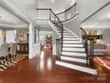 Elegant foyer with curved staircase, hardwood floors, and open floor plan at 5005 Autumn Blossom Ln, Waxhaw, NC 28173