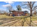 Expansive backyard featuring a two-story brick home with covered porch and a large tree at 605 18Th Nw St, Hickory, NC 28601