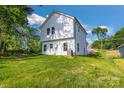 Backyard view of a two-story white home with a large grassy area at 695 S Elm St, Statesville, NC 28677