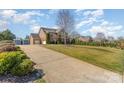 Long driveway leading to a three-car garage and a well-maintained lawn at 8137 Caliterra Dr, Charlotte, NC 28227